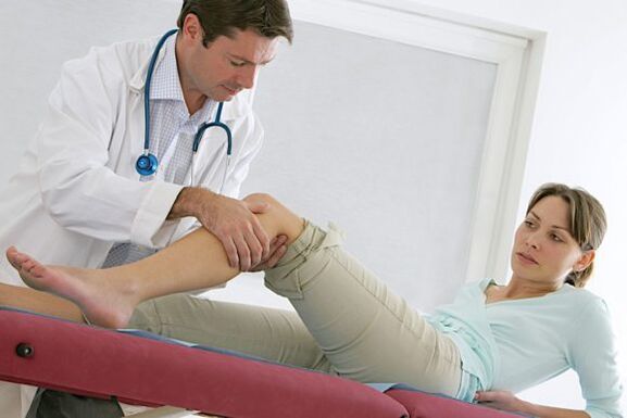 ο γιατρός εξετάζει τα πόδια μετά την επέμβαση για κιρσούς